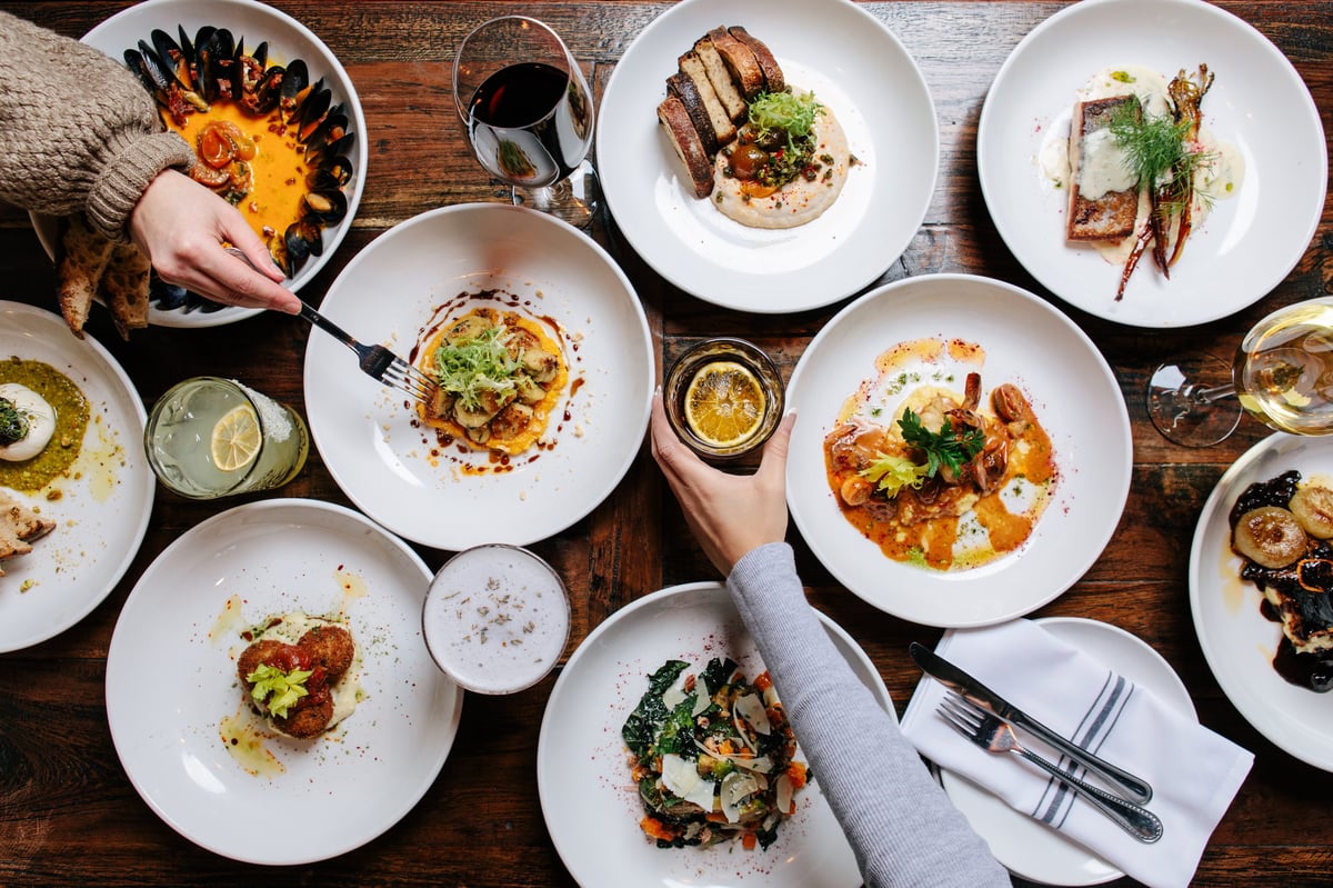 A spread of dishes and drinks on a rustic wooden table